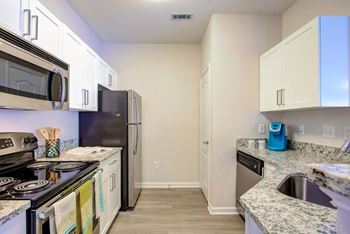A kitchen with a black stove top oven and a black refrigerator.